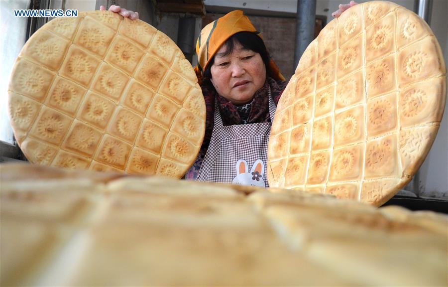 Villagers make traditional food for coming Spring Festival in E China