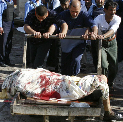 Rescuers remove a body from inside a mosque after suicide bombing in central Baghdad April 7, 2006. Three suicide bombers dressed as women killed at least 79 people at a Shi'ite mosque on Friday in Baghdad, police said, putting more pressure on Iraq's divided leaders to form a government and face up to sectarian violence. [Reuters]