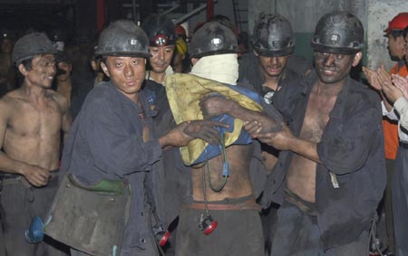 An injured miner (L) receives medical check after an underground passage collapse Xieqiao Coal Mine in East China's Anhui Province October 12 2006. All eight miners trapped underground were rescued and they were in stable condition, Xinhua reported. [Xinhua]