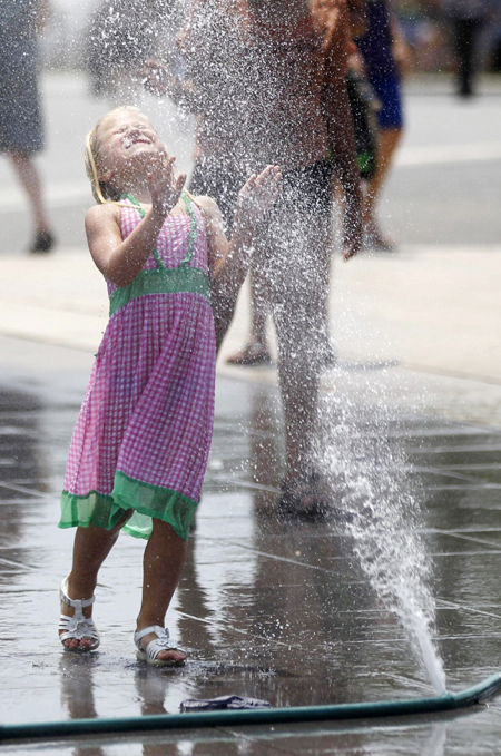 Children play with sprays of water in Washington