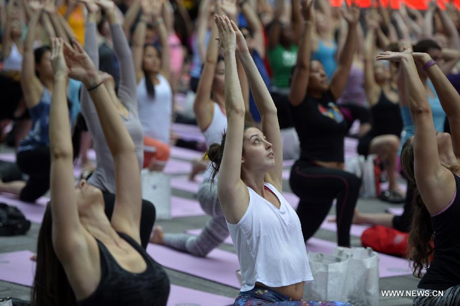 People practice yoga in Times Square to mark Summer solstice day