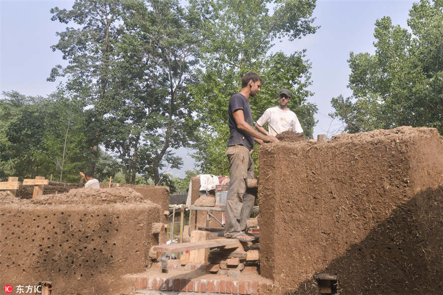 US man building mud house in rural China