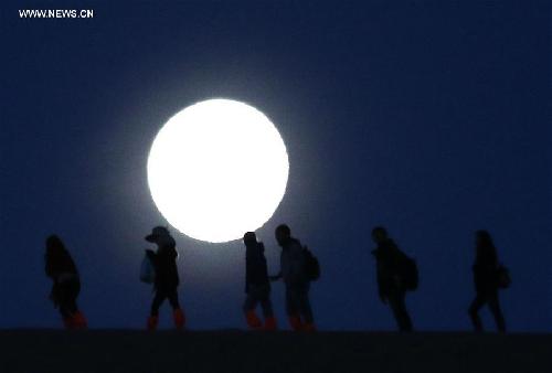 Full moon hikes up Mingsha Mountain in NW China