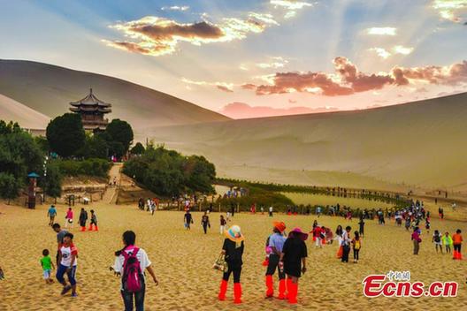 Tourists visit Mingsha Mountain in Dunhuang