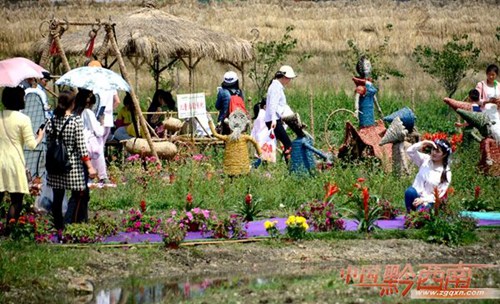 Tourists have fun with straw sculptures in Xingyi