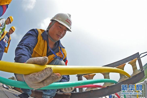 Workers lay power cables on Beijing-Shenyang HSR