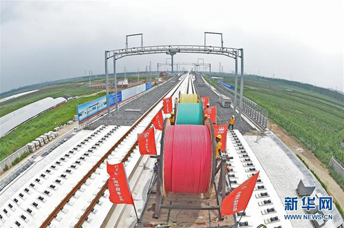 Workers lay power cables on Beijing-Shenyang HSR