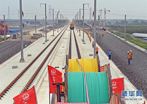 Workers lay power cables on Beijing-Shenyang HSR