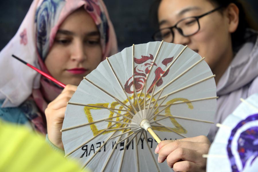 Int'l students paint patterns on umbrellas to greet Year of Rooster