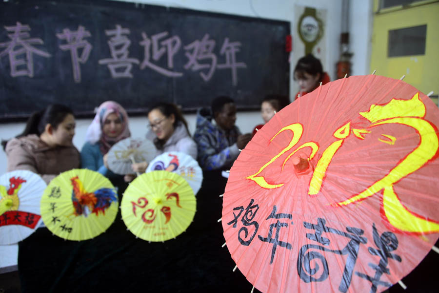 Int'l students paint patterns on umbrellas to greet Year of Rooster