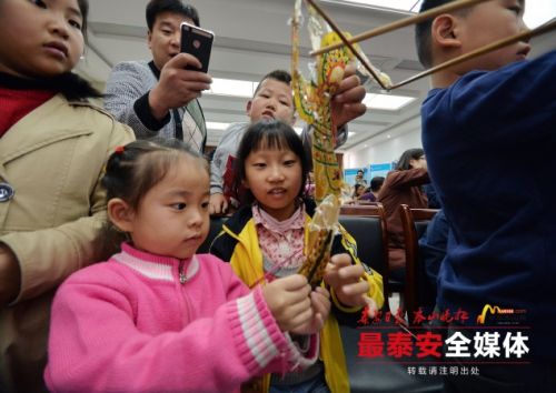 Youngsters play with puppets in Tai'an