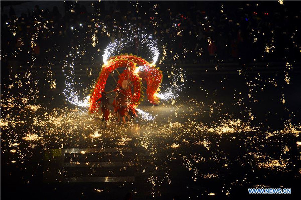 People perform fire dragon dance to welcome new year in E China town