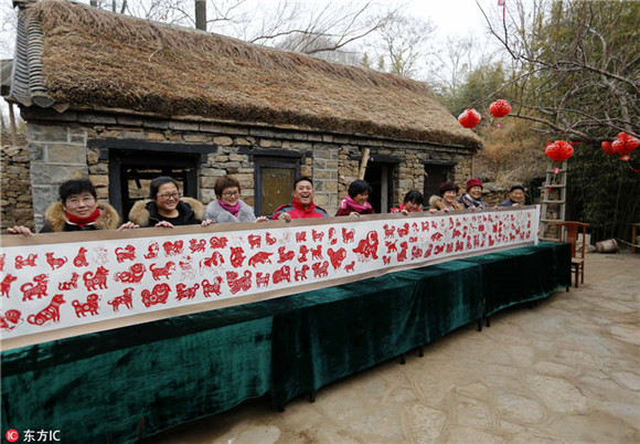 Folk artist creates long scroll of dog-themed paper-cuts