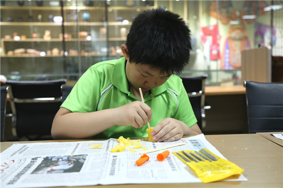 Children learn peach pit carving in Shandong