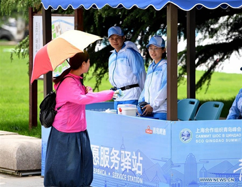 Volunteers seen on street in host city of 18th SCO Qingdao Summit