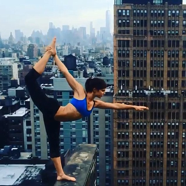 Yogi poses on building ledge<BR>美女子顶楼边缘练瑜伽