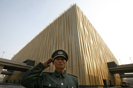 A security guard salutes passing visitors outside the Beijing Olympic Basketball Gymnasium at Wukesong Culture and Sports Center in Beijing February 19, 2008. The gymnasium, which has a seating capacity for 18,000 people, will host basketball competitions during the 2008 Beijing Olympics in August. 