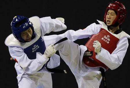China's Lei Jie (R) fights compatriot Zhang Hua in the women's 57Kg final of Good Luck Beijing 2008 International Taekwondo Invitational Tournament at the University of Science and Technology Beijing Gymnasium in Beijing February 27, 2008. Lei won the gold in the Beijing Olympic test event. The gymnasium will hold the judo and taekwondo events in the upcoming Beijing Games in August. [Agencies]