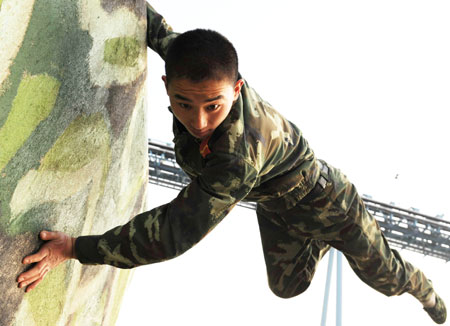 A policeman jumps over a wall during a training session at Qinghuangdao Frontier Inspection Station as part of security preparations for the upcoming Beijing Olympics, March 11, 2008.