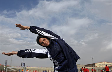 Mahboba Ahdyar, an Afghan runner for the Olympic Games, stretches during a media event in Kabul March 15, 2008. Ahdyar is the only woman among four Afghans due to represent the war-torn country at August's Beijing Olympics and the slightly built 19-year-old 1,500 metre runner stands little chance of a medal. Competing, however, is more about pride and showing the world what Afghan women can do. Picture taken March 15, 2008. [Agencies]