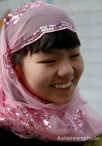 Bai Yuan, a girl of the Hui ethnic group, smiles as she plays with other pupils at Lanzhou Qing Hua Primary School, in Lanzhou, capital of Northwest China's Gansu Province, March 15, 2008. The Beijing Organizing Committee for the Olympic Games (BOCOG) recently invited the school, which is known for having students from many ethnic groups, to submit photographs of smiling children for possible use in the August 8 Opening Ceremony of the Beijing Olympic Games. BOCOG started collecting photographs of children's smiling faces from around the world on Sept 4 last year. [Asianewsphoto] 