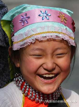 Ma Li, a girl of the Hui ethnic group, smiles as she plays with other pupils at Lanzhou Qing Hua Primary School, in Lanzhou, capital of Northwest China's Gansu Province, March 15, 2008. The Beijing Organizing Committee for the Olympic Games (BOCOG) recently invited the school, which is known for having students from many ethnic groups, to submit photographs of smiling children for possible use in the August 8 Opening Ceremony of the Beijing Olympic Games. BOCOG started collecting photographs of children's smiling faces from around the world on Sept 4 last year. [Asianewsphoto] 