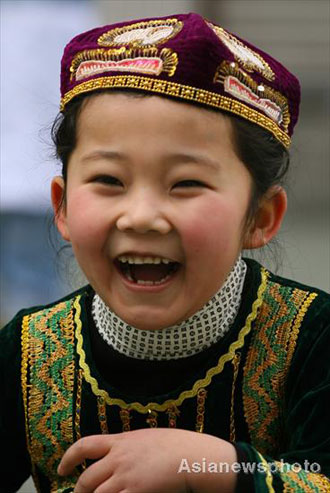 Yue Jiaxuan, a girl of the Hui ethnic group, smiles as she plays with other pupils at Lanzhou Qing Hua Primary School, in Lanzhou, capital of Northwest China's Gansu Province, March 15, 2008. The Beijing Organizing Committee for the Olympic Games (BOCOG) recently invited the school, which is known for having students from many ethnic groups, to submit photographs of smiling children for possible use in the August 8 Opening Ceremony of the Beijing Olympic Games. BOCOG started collecting photographs of children's smiling faces from around the world on Sept 4 last year. [Asianewsphoto] 