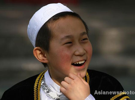 Hai Rui, a boy of the Hui ethnic group, smiles as he plays with other pupils in Lanzhou Qing Hua Primary School, at Lanzhou, capital of Northwest China's Gansu Province, March 15, 2008. The Beijing Organizing Committee for the Olympic Games (BOCOG) recently invited the school, which is known for having students from many ethnic groups, to submit photographs of smiling children for possible use in the August 8 Opening Ceremony of the Beijing Olympic Games. BOCOG started collecting photographs of children's smiling faces from around the world on Sept 4 last year. [Asianewsphoto] 