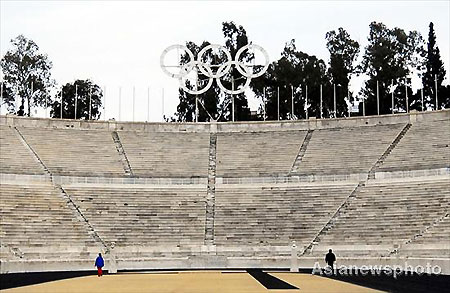 Two Athenians walk inside the Panathenaic Stadium in Athens, where the first modern Olympics were held in 1896, in this photo taken on March 20, 2008. The Olympic flame, which will be lit on March 24 in Olympia, Greece, will be handed over to the Beijing Olympic Committee on March 30 at a ceremony in the Panathenaic Stadium made of marble. [Asianewsphoto]