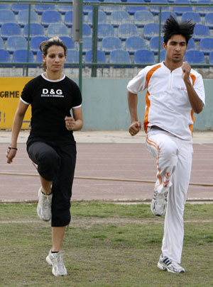 Iraqi sprinter Dana Abdul-Razzaq (L) exercises with her fiance during a training session al-Shaab National Stadium in Baghdad March 18, 2008. Abdul-Razzaq will be Iraq's only female athlete at the Beijing Olympics. [Agencies]