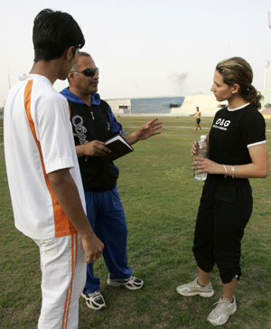 Iraqi sprinter Dana Abdul-Razzaq listens to her coach Yousif Abdul-Rahman (2nd L) during a training session at al-Shaab National Stadium in Baghdad March 18, 2008. Abdul-Razzaq will be Iraq's only female athlete at the Beijing Olympics. [Agencies]