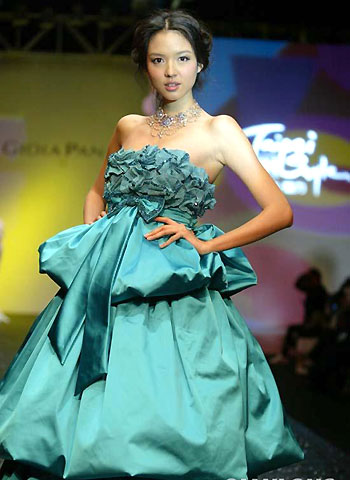 Zhang Zilin, who was crowned Miss World 2007, presents a creation by Taiwan designer Pan Yiliang in Beijing March 31, 2008. Zhang recently finished recording an Olympic song called 'The world follows me'. [Qianlong.com]