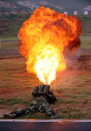 A member of China's armed police operates a flame sprayer during an anti-terrorist drill held in Jinan, capital of east China's Shandong Province July 2, 2008, roughly one month ahead of the Beijing Olympics.(Xinhua/Fan Changguo Photo)