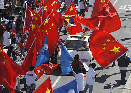 Torch relay supporters, waving Chinese and Olympic torch relay flags, halt a Tibetan separatists' bus before the beginning of the Olympic Torch relay in San Francisco, California April 9, 2008. The International Olympic Committee has no plans to stop the Beijing Olympic torch relay despite recent disruptions by Tibetan separatists and their supporters, IOC president Jacques Rogge said in Beijing on Thursday. [sohu.com]