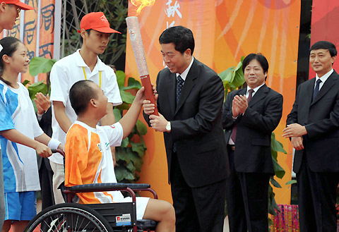 Cheng Run'er (Third R), the governor of Changsha presentes the Paralympic torch to Zhu Weimin(B), swimming gold medalist in 1996 Atlanta Paralympics. The Beijing Paralympic torch relay made its tour in Changsha, Hunan province on August 31,2008. [Xinhua]