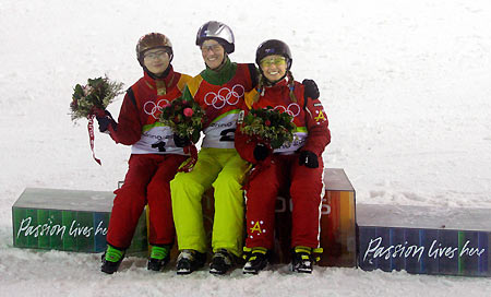 Evelyne Leu (C) of Switzerland celebrates during the final of the women's aerials freestyle competition at the Torino 2006 Winter Olympic Games in Sauze dOulx, Italy February 22, 2006. Leu is flanked by China's Li Nina (L) and Australia's Alisa Camplin (R).[Reuters]