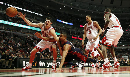 Chicago Bulls guard Kirk Hinrich (L) escapes Cleveland Cavaliers forward center Alan Henderson (2nd L) during the first half of their NBA game in Chicago March 2, 2006. [Reuters]