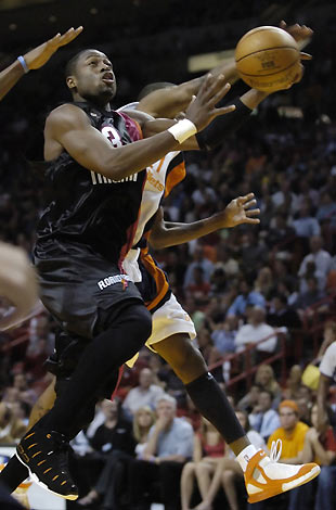 Miami Heat guard Dwyane Wade (L) drives to the basket on guard Donell Tayor of the Washington Wizards during NBA action in Miami, Florida March 8, 2006. [Reuters]