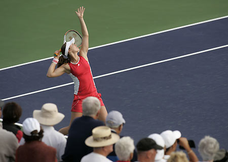 Martina Hingis of Switzerland serves as fans look on during a practice session with Justine Henin-Hardenne at the Pacific Life Open tennis tournament in Indian Wells, California, March 9, 2006.[Reuters]