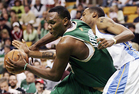 Denver Nuggets' Marcus Camby (R) tries to knock the ball away from Boston Celtics' Al Jefferson in the fourth quarter of their NBA game in Boston, Massachusetts March 12, 2006. Boston won 106-101. [Reuters]