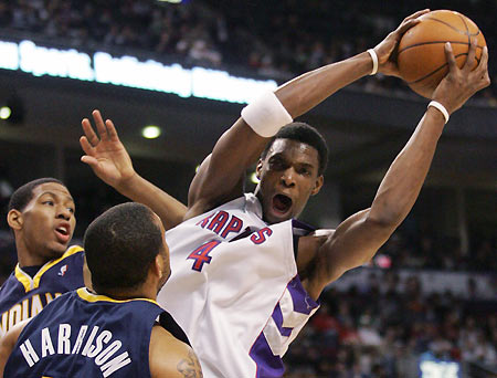 Toronto Raptors forward Chris Bosh (R) grabs a rebound while battling Indiana Pacers centre David Harrison (L) for possession during the first half of their NBA game in Toronto, March 12, 2006. [Reuters]