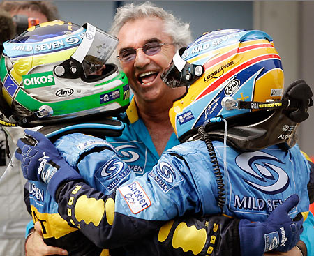 Renault Formula One drivers Giancarlo Fisichella (L) of Italy and Fernando Alonso (R) of Spain celebrate with managing director Flavio Briatore after placing first and second respectively at the Malaysian F1 Grand Prix in Sepang, near Kuala Lumpur March 19, 2006. [Reuters]