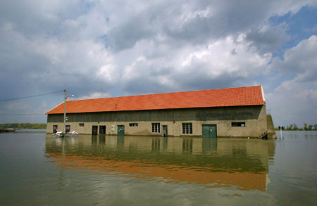 A house is reflected in the Danube River in the village of Ritopek near Belgrade April 17, 2006. The Danube peaked at record highs in Serbia on Monday without overwhelming flood defences, but authorities warned there was still danger waterlogged dykes could collapse and wreak havoc across southeastern Europe. [Reuters]