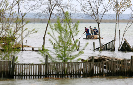 Romanians in a makeshift boat pass flooded houses by Danube river in Fetesti, 150km (93 miles) east of Bucharest, Romania, April 17, 2006. Fed by heavy rain and melting snow from central Europe, the Danube hit its highest level for 111 years over the weekend in Romania and Bulgaria, displacing hundreds of people and threatening to swamp the homes of tens of thousands more. [Reuters]