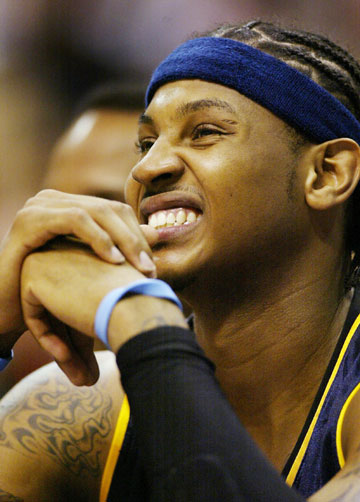Denver Nuggets Carmelo Anthony reacts on the bench as he watches teammate Marcus Camby miss a free throw on the court in the second quarter of game 2 of the NBA Western Conference first round playoff series against the Los Angeles Clippers in Los Angeles April 24, 2006.