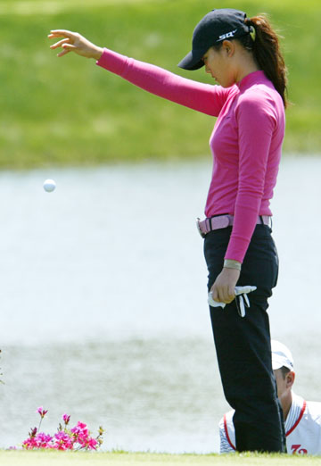 American golfer Michelle Wie drops a ball after her ball went into a hazard on the 4th hole of the SK Telecom Open 2006 golf tournament at the Sky 72 Golf Club in Inchon, west of Seoul, May 7, 2006. 