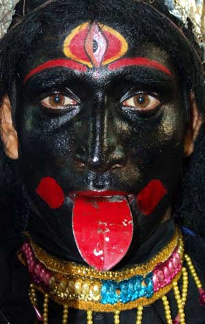 Rana Bhattacharya, an unemployed youth, walks down a busy lane dressed up as the Hindu goddess Kali ( the Goddess of power) in the eastern Indian city of Kolkata May 9, 2006. 