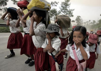 Student cover their nose and mouth during an ash rain at Ketep village, near Indonesia city of Muntilan on May 15, 2006. Ash rain triggered by hot smoke coming out of Indonesia Mount Merapi volcano on Monday feel on some parts of the volcano's slopes. [Reuters]