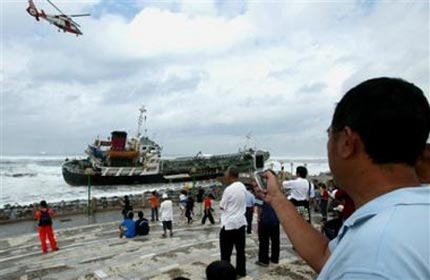 A helicopter lifts a crew members off an oil tanker which ran aground, May 17, 2006, in Kaoshiung, 350 kilometers (217 miles) south west of Taipei. The tanker ran aground in stormy seas swollen by typhoon Chanchu. The typhoon, the strongest ever reported in the South China Sea in May, was expected to pass between Hong Kong and Taiwan on Wednesday and slam into Guangdong province on Thursday morning. [AP Photo]