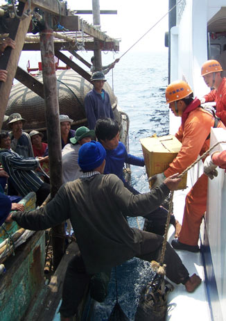 Chinese rescuers provide food to Vietnamese fishermen on a boat in the South China Sea, May 20, 2006. Chinese rescue teams saved at least 330 Vietnamese fishermen from the fury of Typhoon Chanchu over the weekend the largest number of foreigners rescued by China's maritime officials. [Xinhua]